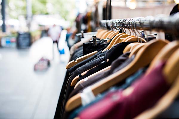 imagem de cabides com roupas em loja de departamento